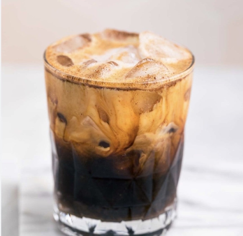 An iced specialty latte finished with cold foam.