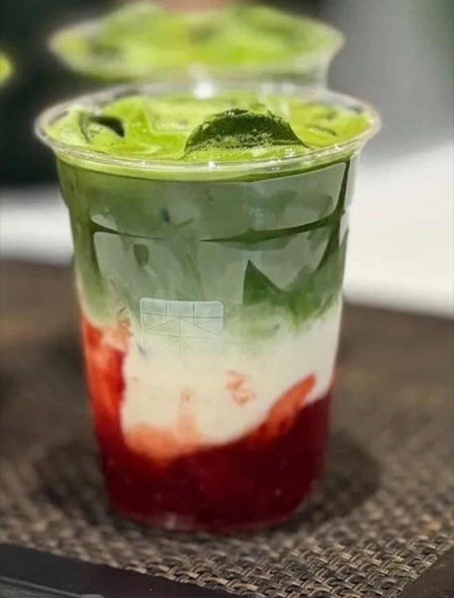 A layered Calhoun Coffee strawberry matcha — bright green matcha over pink strawberry.
